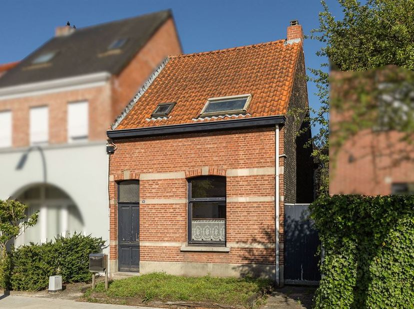 Te renoveren dorpswoning in doodlopende straat. Gelijklvloers : inkomhal met gastentoilet, living op vast tapijt en voorzien van een houthaard en inge