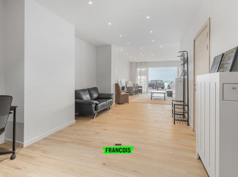 Bij het binnenkomen in dit appartement word je meteen verwelkomd door een uitzonderlijk ruime leefruimte, die het kloppende hart van de woning vormt.
