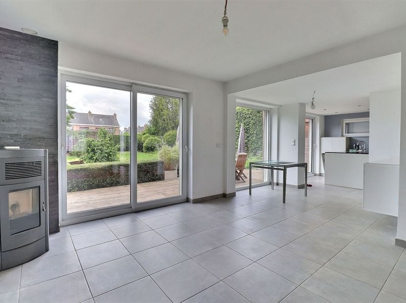 Jolie maison semi mitoyenne comprenant hall d'entrée, séjour avec cuisine équipée ouverte, buanderie, cave, garage, WC séparé et jardin avec terrasse.