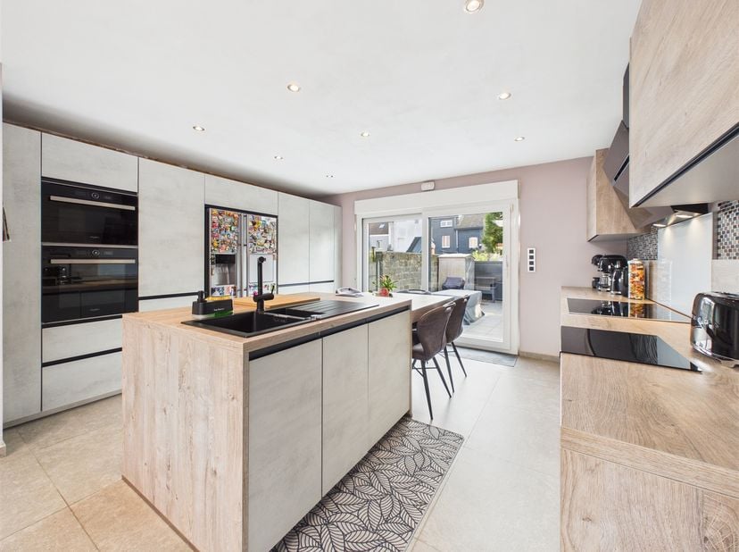 Dès le rez-de-chaussée, la maison vous accueille par un hall d'entrée qui s'ouvre sur un vaste living de plus de 32 m².<br />
Dans son prolongement,