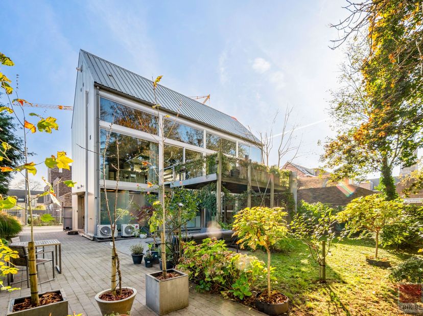 Unieke architectenwoning met stalen constructie en glazen achtergevel in Maasmechelen. Gelegen in een groene oase biedt deze woning een combinatie van