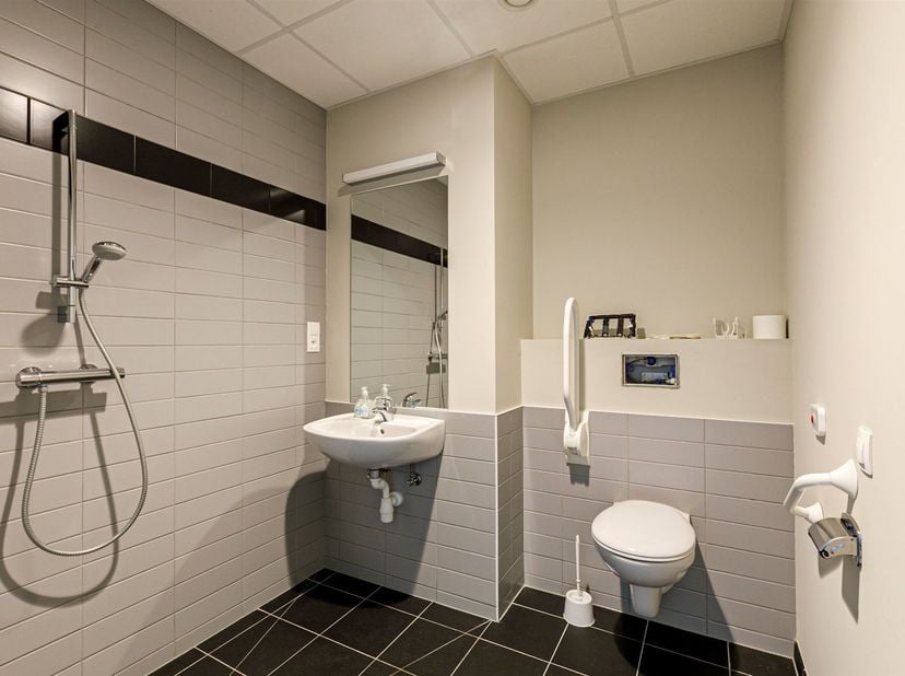 Dit appartement is gelegen in een modern appartementsgebouw in Grobbendonk, dat specifiek ontworpen is voor assistentie woningen. Het gebouw biedt een