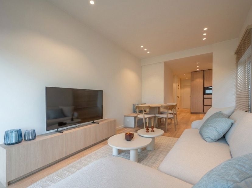 Op de Zeedijk van Heist, op wandelafstand van het strand en de kustlijn richting Knokke, biedt dit volledig gerenoveerde appartement een interieur dat