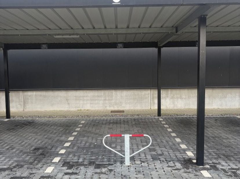 Te koop aangeboden: een overdekte parkeerplaats gelegen aan de Sportlaan in Bree, achter de winkelsite. Deze parkeerplaats bevindt zich op een uitstek