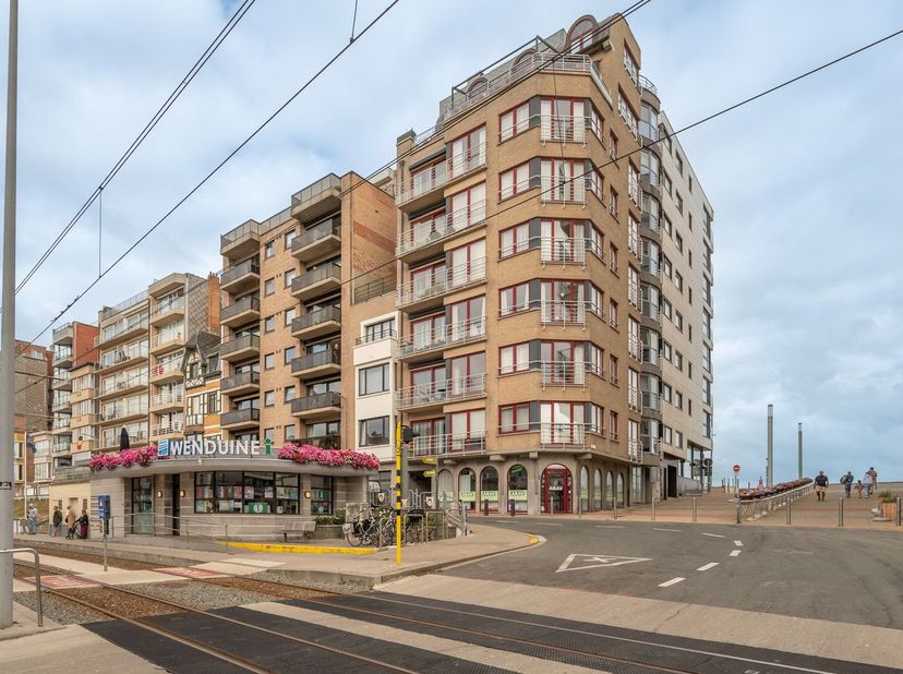 Uitstekend gelegen hoekappartement met twee slaapkamers, centraal in het gezellige Wenduine, op de hoek van de Graaf Jansdijk en de Floorhelling. Dank