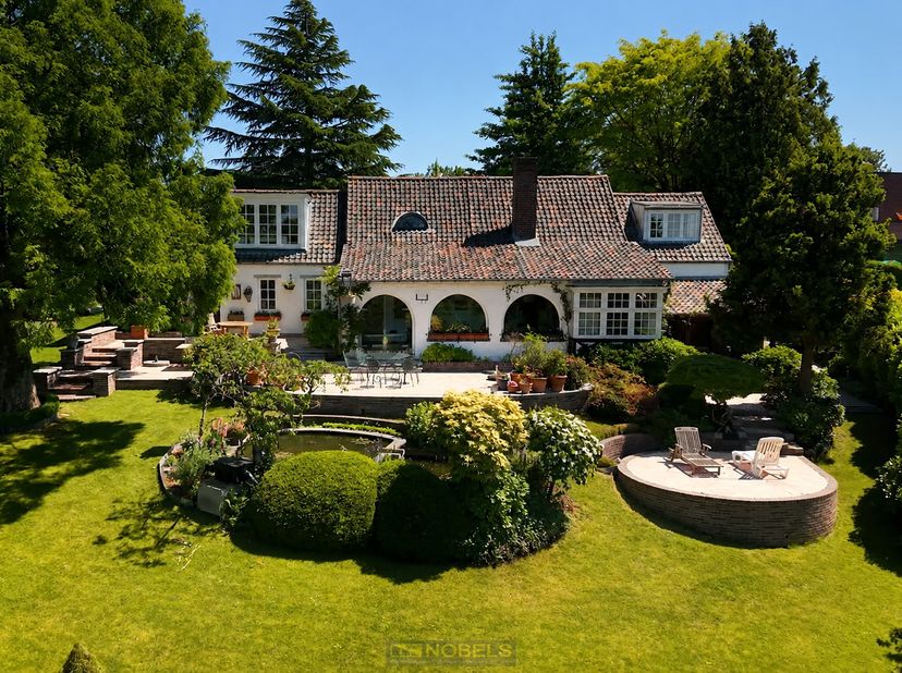 VERSCHOLEN IN HET GROEN en OMGEVEN DOOR RUST bevindt zich dit CHARMANTE LANDHUIS op een perceel van ca. 7.200 m², een UNIEKE EIGENDOM waar NATUUR, PRI