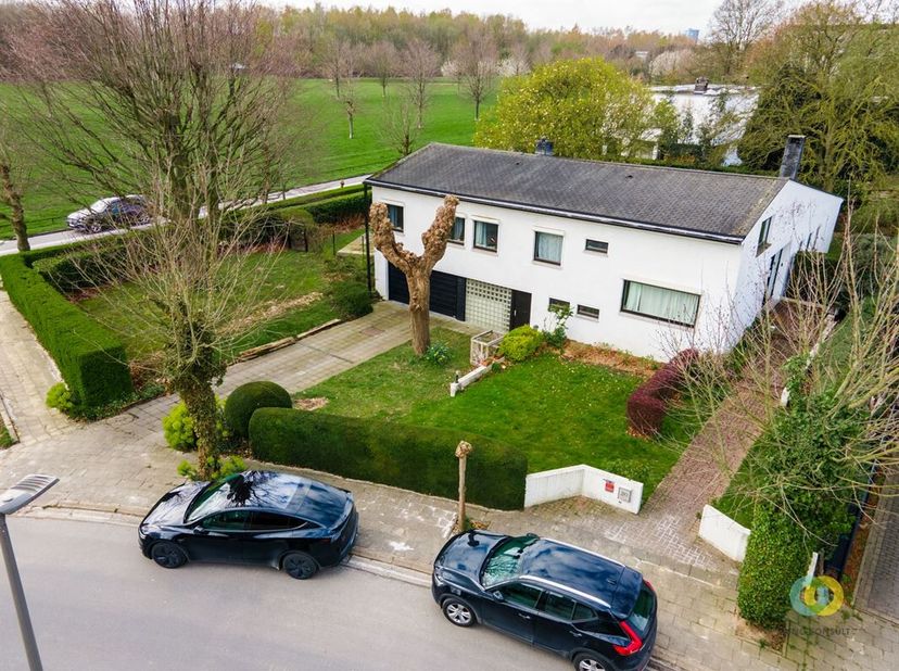 **IN OPTIE** Deze uitzonderlijk gelegen villa combineert ruimte, licht en veelzijdigheid met een uniek karakter. Via de inkomhal met hoge glaspartij b