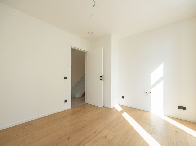 In een doodlopende straat (zone 30), omringd door groen, bevindt zich deze nieuwbouwwoning in open bebouwing op een perceel van 1.000 m². De woning wo