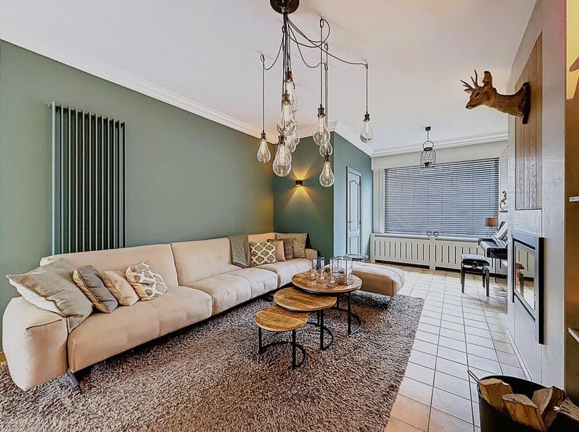 Instapklare woning nabij het centrum bestaande uit een inkomhal, gezellige leefruimte met eet-en zithoek, polyvalente ruimte, uitgeruste keuken, buree