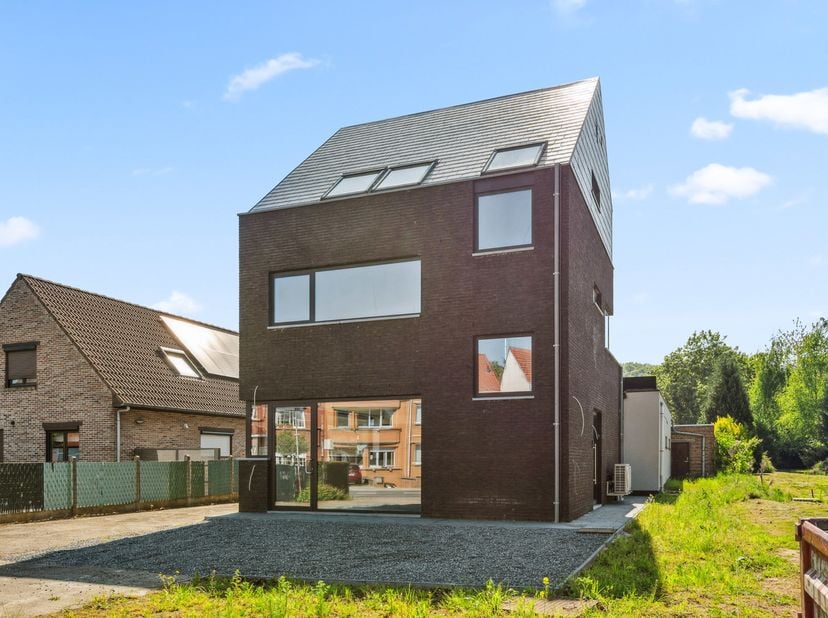 Découvrez ce bâtiment polyvalent et économe en énergie, composé d'un espace commercial, d'un appartement duplex et d'un vaste entrepôt, situé sur un t