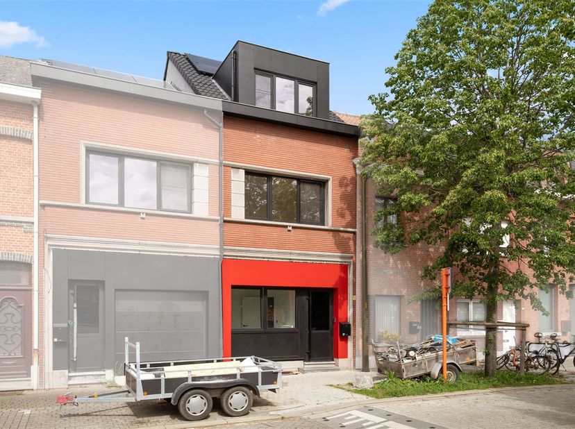 In het hart van Muizen, midden in een zone 30, ligt deze vernieuwde rijwoning, met veel blauwe hardsteen aan de gevel, gecombineerd met een rood-zwart