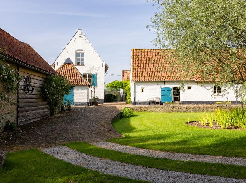 Te midden van een prachtig groen domein van bijna 12.000 m² bevindt zich deze karaktervolle hoeve met een indrukwekkende bewoonbare oppervlakte van ma