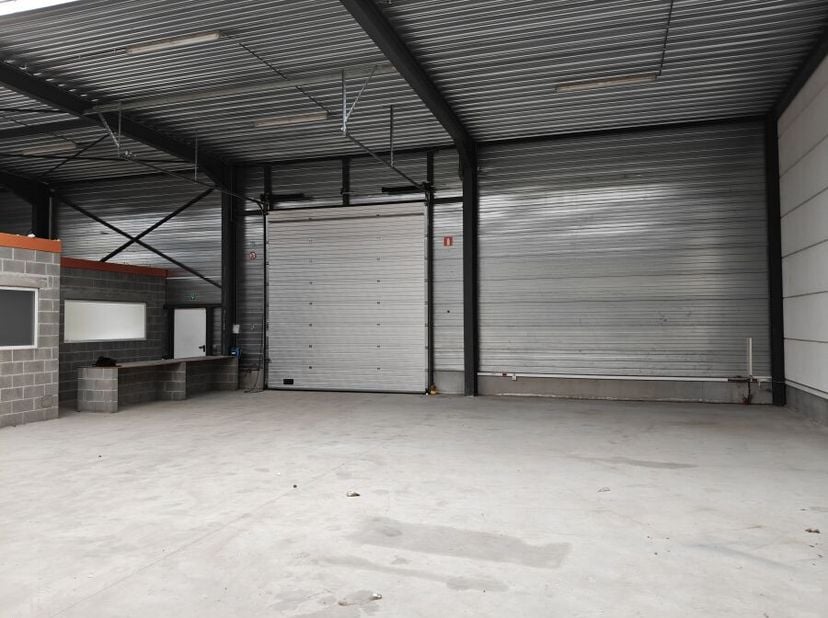 Deze magazijnunit van 432 m² is gelegen achterin een groter bedrijfsgebouw op de industriezone Lerenveld te Lint, tussen Lint en Lier. De unit beschik