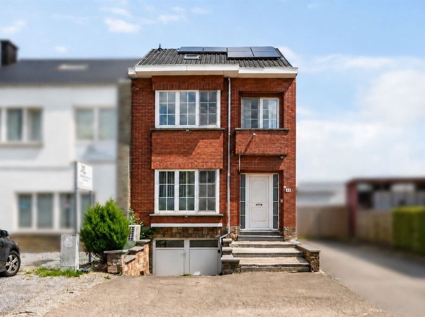 Gerenoveerde halfopen woning met drie slaapkamers, garage, zonnepanelen en een volledig afgewerkte zolder, gelegen nabij het centrum van Sint-Truiden.