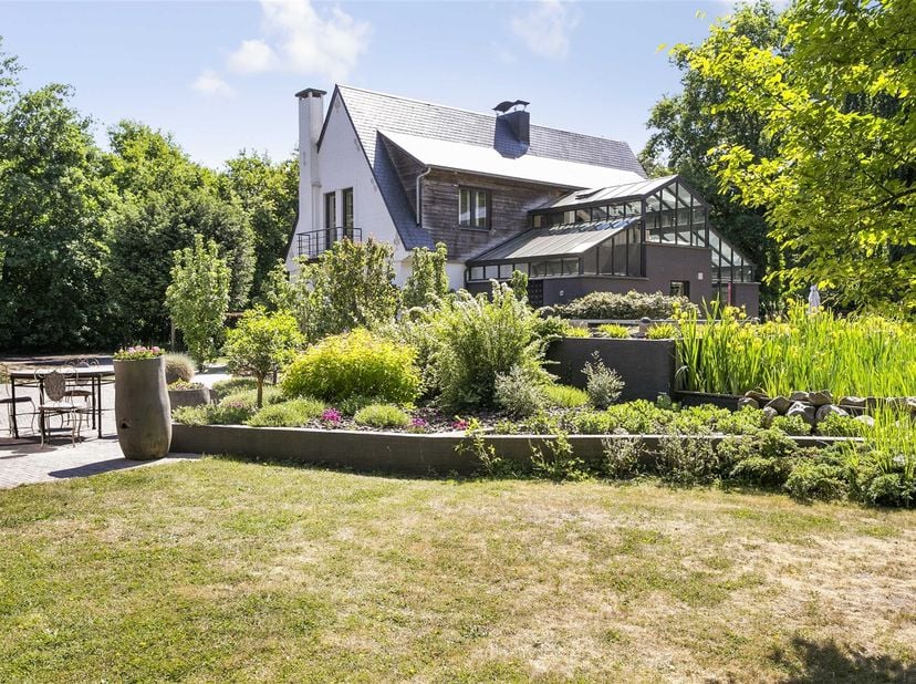 Architectuur en natuur in harmonie op Hazendreef 11 is een unieke woonkans aan het einde van een rustige dreef, ingeklemd in een groene oase. Deze won