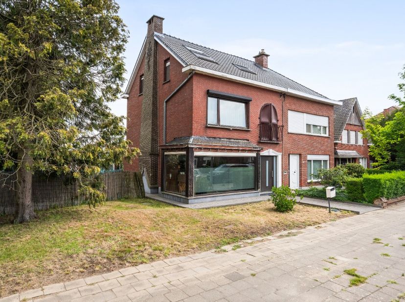 De woning omvat een inkomhal, een ruime leefruimte en een lichtrijke veranda met open ingerichte keuken en praktische berging. Op de 1ste verdieping b