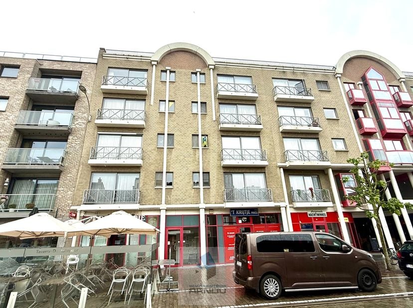 Dit aangename appartement verwelkomt u in een ruime inkomhal en biedt een bijzonder lichtrijke leefruimte met uitzicht op de Markt. Aansluitend vindt