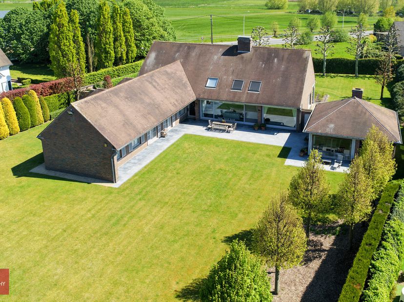 Bestaande uit inkomhal, ruime living met parket en open haard, eetplaats, ingerichte keuken met ontbijthoek, wasplaats, gelijkvloerse slaapkamer met d