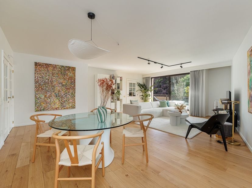Niché au cœur d’un magnifique domaine arboré de 5.783 m², cet élégant appartement de ± 133 m² séduit par son calme, son confort et son excellent état