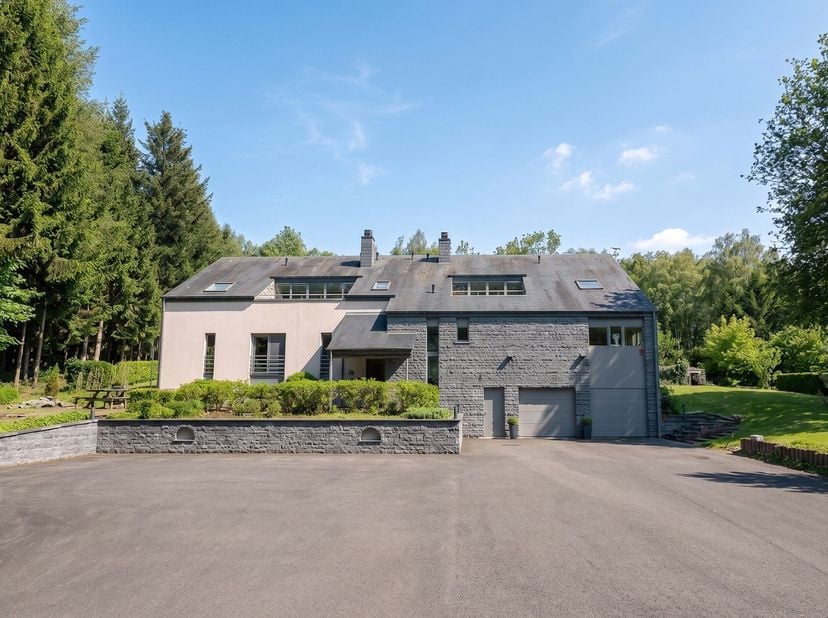 Gelegen nabij Houffalize, op een perceel van ongeveer 1,47 hectare met aangelegde tuin en privébos, biedt dit hedendaagse landgoed circa 700 m² bewoon