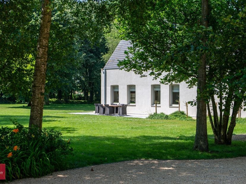Een oase van rust. Afgeschermd door parktuin met vijver en volgroeide bomen bevindt zich deze villa bestaande uit een inkomhall, living met open hard