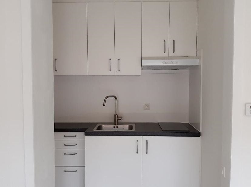 Gezellig instapklaar appartement 1e verdieping links.  Bestaande uit hall, living met open keuken (kasten, enkele inox afwasbak, keramische kookplaten