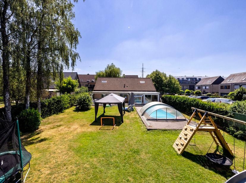 Deze instapklare en ruime gezinswoning biedt 239 m² bewoonbare oppervlakte, vijf slaapkamers, twee badkamers en een prachtige tuin van 1140 m² met zwe