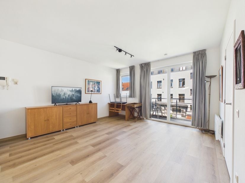 Op slechts enkele minuten wandelen van het centrum van Brussel biedt dit gerenoveerde appartement een praktische indeling en een terras gericht op het