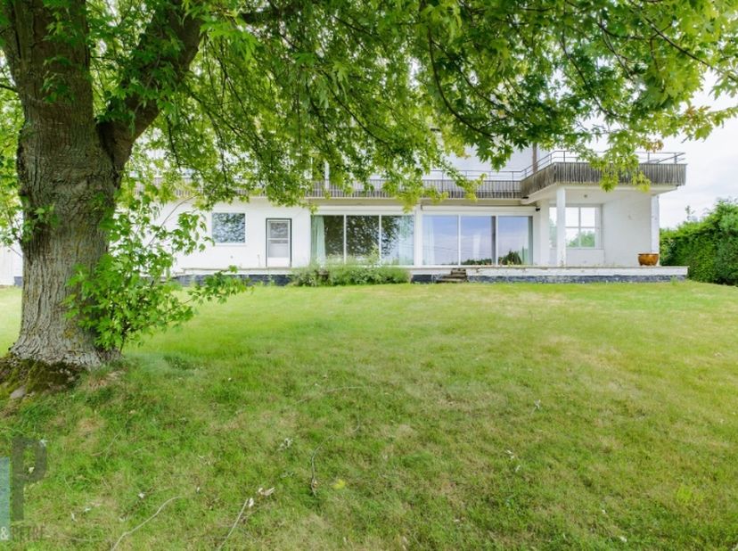 Deze karaktervolle voormalige dokterswoning (bouwjaar 1961) biedt een uitzonderlijke bewoonbare oppervlakte van maar liefst 439 m² en combineert ruimt
