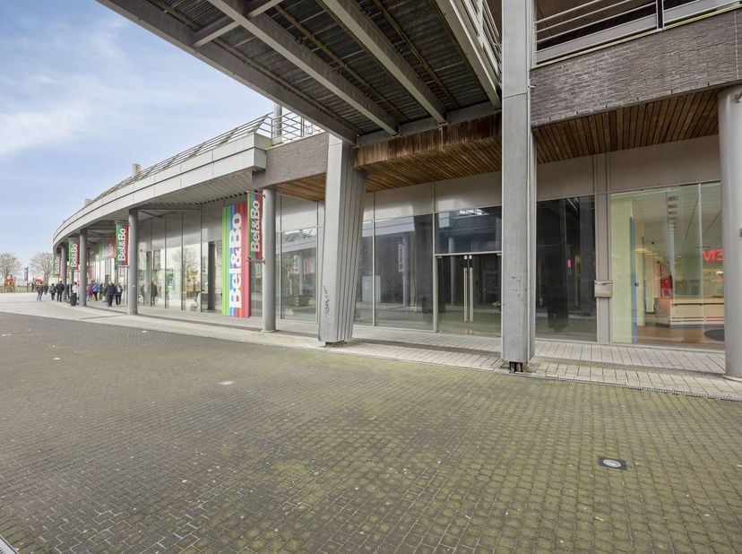 Dit ruime handelspand van ca. 425 m² is gelegen in een goed bereikbaar en commercieel aantrekkelijk shoppingcenter in Maaseik, waar het geniet van een