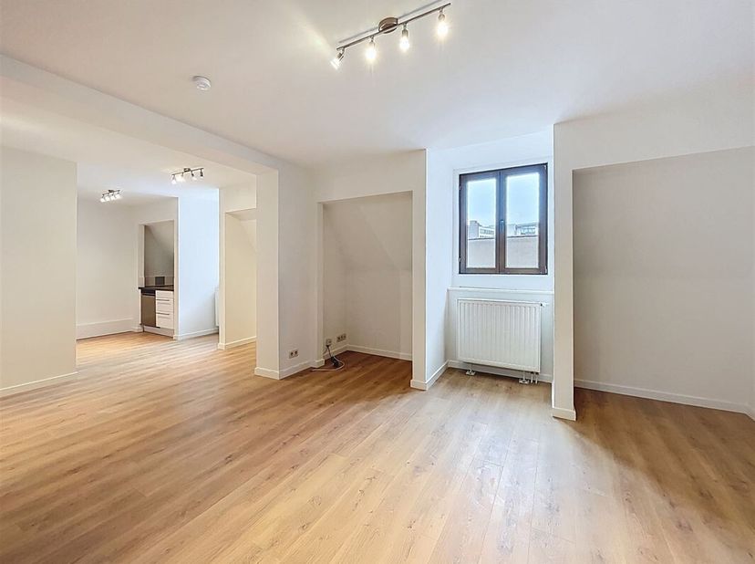 250m van de Grote Markt. Ruime duplexwoning van 85m². Het bestaat uit een inkomhal met vestiaire, een woonkamer van +/-25m² met ingerichte keuken, een