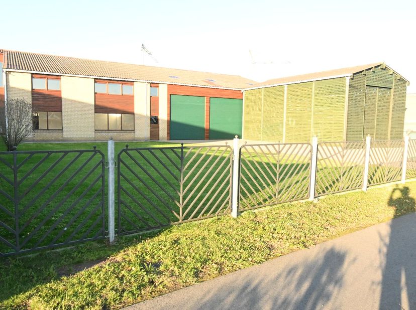 Vrijstaande loods met oprit, parkeerplaatsen en tuin.<br />
Totale oppervlakte terrein: +/- 1.500 m².<br />
Rechtstreekse toegang vanaf de openbare we