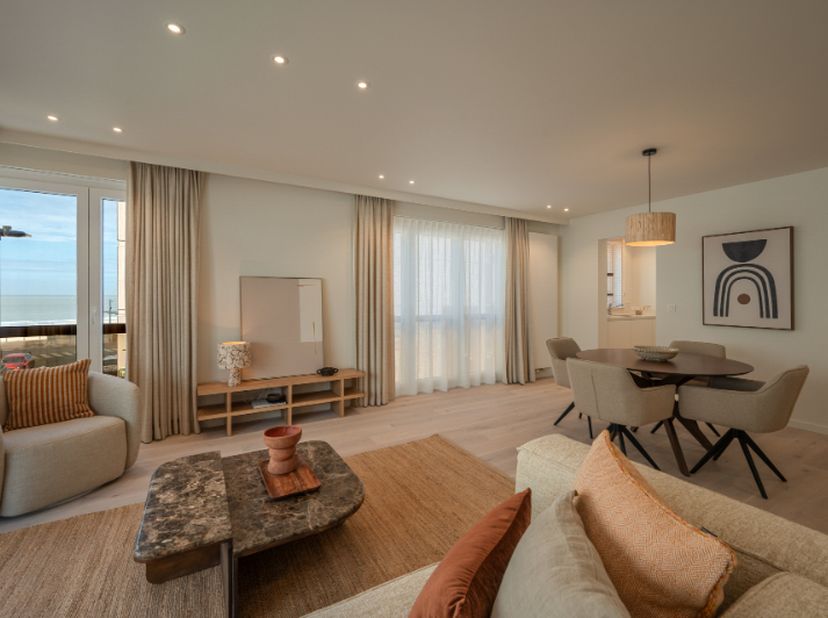 Dit subliem afgewerkt appartement omvat een elegante inkomhal met vestiairekast en gastentoilet, een uitzonderlijk lichtrijke leefruimte met een ademb