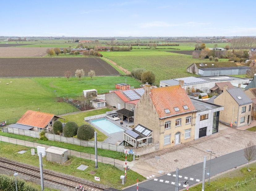 In Avekapelle (Veurne) vinden we deze woning met kantoorgebouwen en loodsen terug.WONING Bij binnenkomst bevindt zich een inkomhal met een afzonderlij