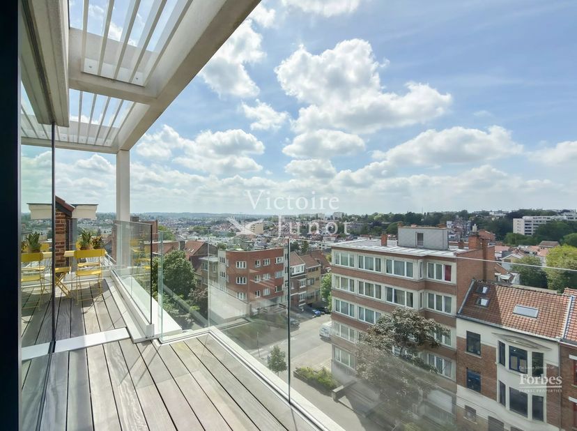 Exclusief te ontdekken bij Victoire-Junot, in de gegeerde Coghenwijk, dit hedendaagse penthouse van ± 130 m² bruto-oppervlakte, recent gebouwd binnen