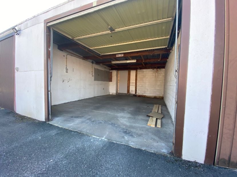 Gemetste garage met metalen kantelpoort.<br />
Afmetingen: +/- 5,4 m x 4 m.<br />
Onmiddellijk. (enkel privatieve huur)