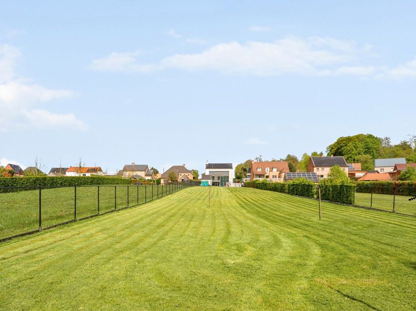 Op een perceel van maar liefst 3.947 m² bevindt zich deze hoogwaardige, moderne recente woning die ruimte, privacy en kwaliteit perfect combineert. Me