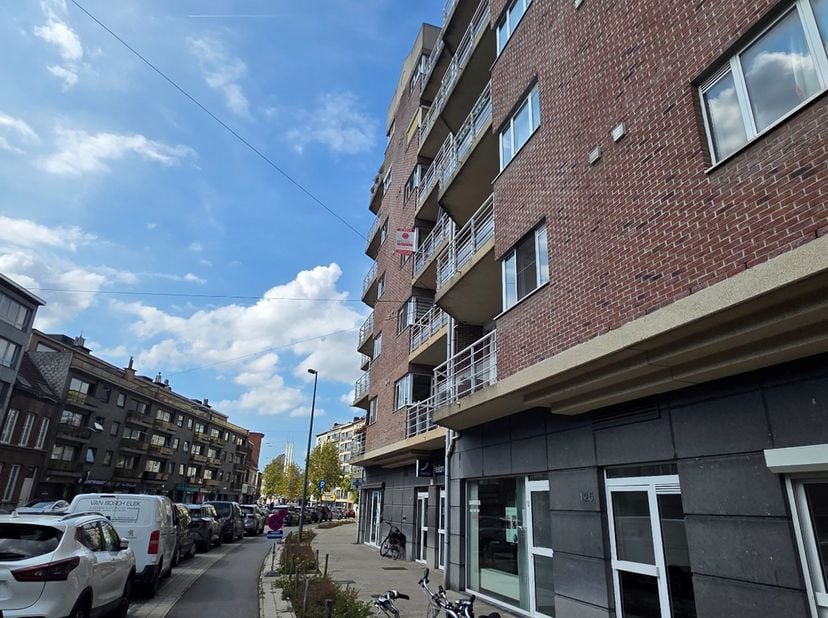 De toegang tot het appartement is via de centraal gelegen inkomhal die doorgang geeft naar de ruime woonkamer en de keuken. Langsheen de woonkamer kan