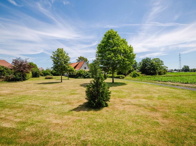 LIGGING<br />
Deze karaktervolle hoeve geniet van een rustige en landelijke ligging te Poesele, een charmante deelgemeente van Deinze. Omgeven door ui