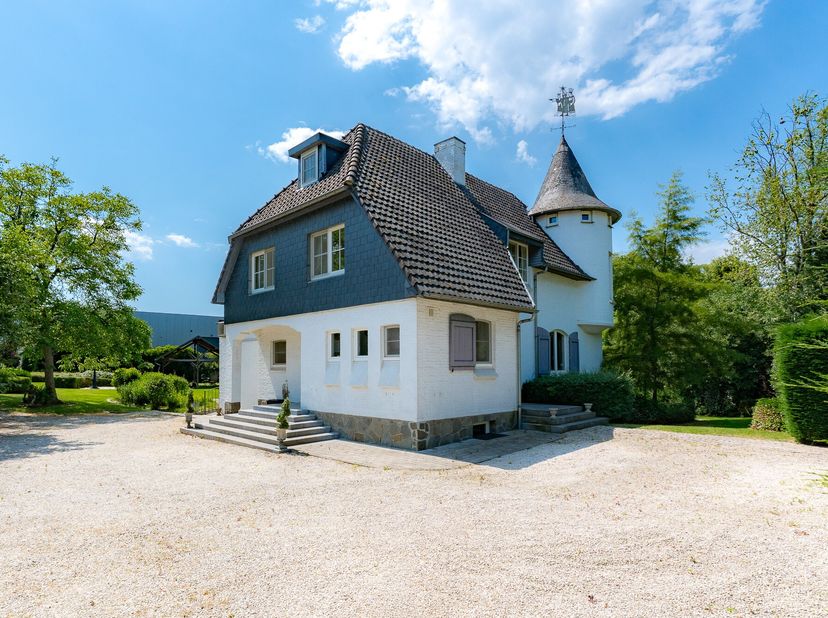 Verscholen in een groene en residentiële omgeving nabij Hasselt bevindt zich deze uitzonderlijke karaktervilla, een eigendom waar architecturale charm