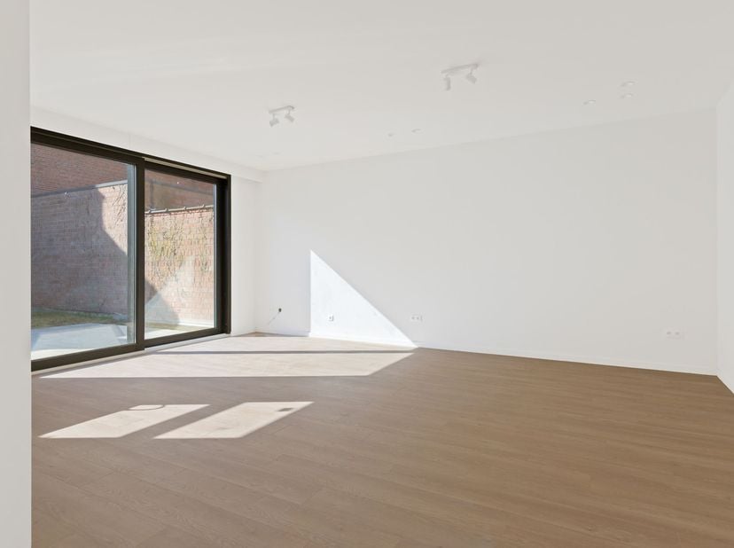 Appartement entièrement rénové et économe en énergie, comprenant 2 chambres, une terrasse, un petit jardin et une place de parking, situé dans le cent