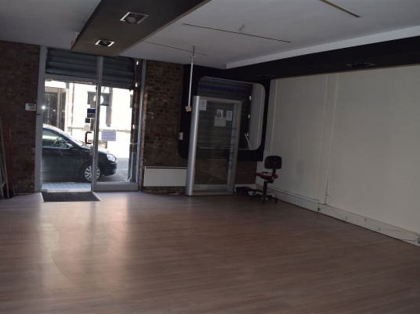 Winkelruimte van +/- 63 m² gelegen in het centrum van Péruwelz, bestaande uit een ontvangstruimte van 55 m², een opslagruimte/keuken van 6,6 m², een t