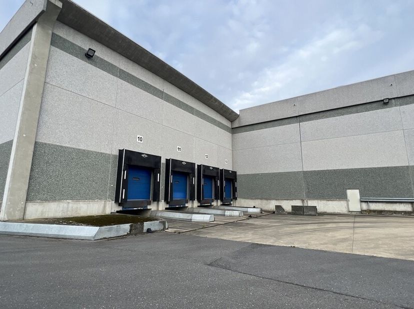 5222m² magazijn met 4 laadkades (uitbreidbaar tot 9555m² magazijn)<br />
Ligging: op bedrijventerrein Zone 2: Entrepotstraat vlakbij R42 met vlotte ve