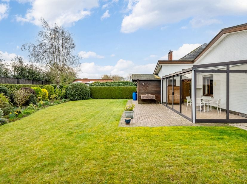 e bungalow solidement construit, avec garage, jardin, terrasse et véranda, situé sur un terrain de 825 m², bénéficie d’un emplacement très calme dans