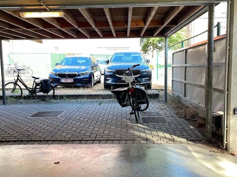 De staanplaats bevindt zich onder een carport en is bereikbaar via een afgesloten toegangspoort met code, wat zorgt voor extra veiligheid en privacy.<