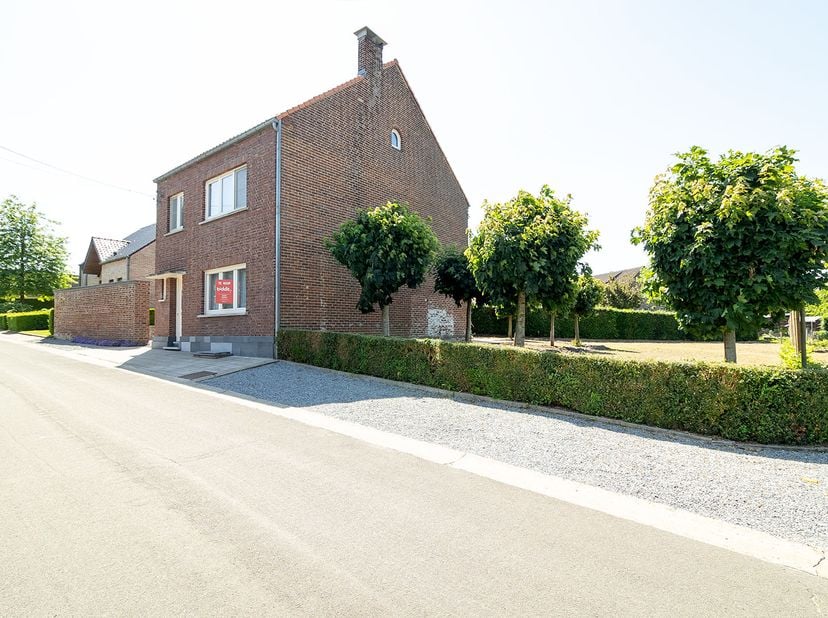 WONING MET TUIN<br />
<br />
Woning (OB) met tuin, groot 8a 20ca, omvattende:<br />
- gelijkvloers: inkomhall met trap naar boven, ruime living met pa
