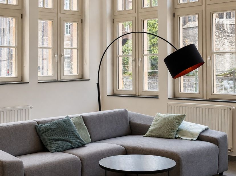 TE HUUR - GENT. Op een uitzonderlijke locatie aan het water: een charmant gelijkvloers appartement van maar liefst 142 m² aan de Predikherenlei. Het a
