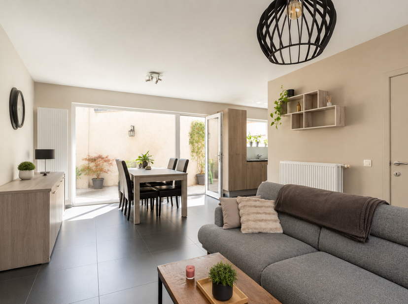 Via le hall d’entrée, vous accédez à cette habitation élégante et parfaitement entretenue, où vous êtes immédiatement accueilli dans un espace de vie