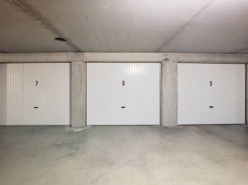 Ce box de garage central (n° 7), équipé d'éclairage et d'électricité, est situé dans la résidence Duinzicht III, au Duinenweg 231A à Middelkerke. Le b