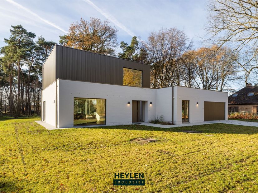 Gelegen aan een met bomen omzoomde laan, straalt deze vernieuwbouwvilla pure rust en verfijning uit. Omringd door groen en grenzend aan de prestigieuz